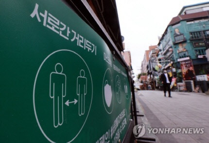 24일 서울 용산구 이태원 세계음식거리 한 가게 입구에 사회적거리두기와 코로나19?방역 캠페인 내용이 적힌 배너가 세워져 있다. <연합뉴스>